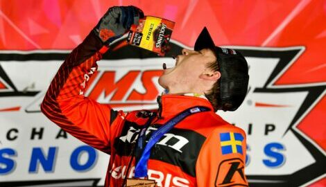 Emil Harr on the finishing podium, leaning over and pouring a bag of Jack Link's Teriyaki Beef Jerky into his mouth.