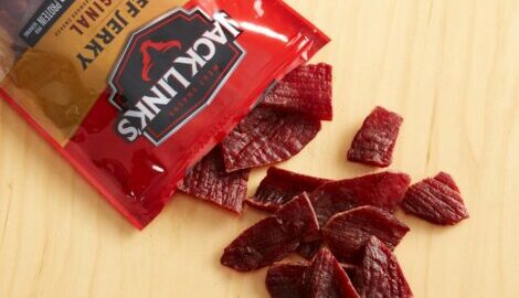 Our Original Beef Jerky opened and spilling out onto a light wood countertop.