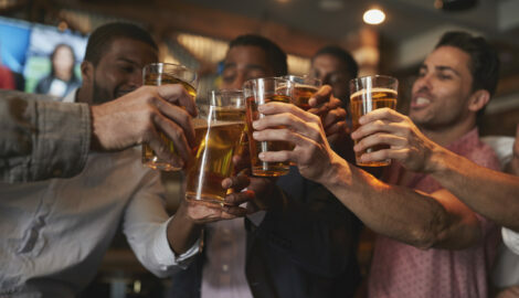 Group Of Male Friends On Night Out For Bachelor Party In Bar Making A Toast Together